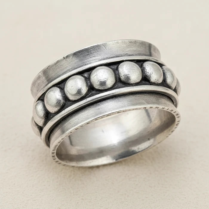 Silver spinner ring with raised round bead details on the outer band