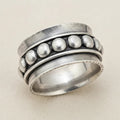 Silver spinner ring with raised round bead details on the outer band