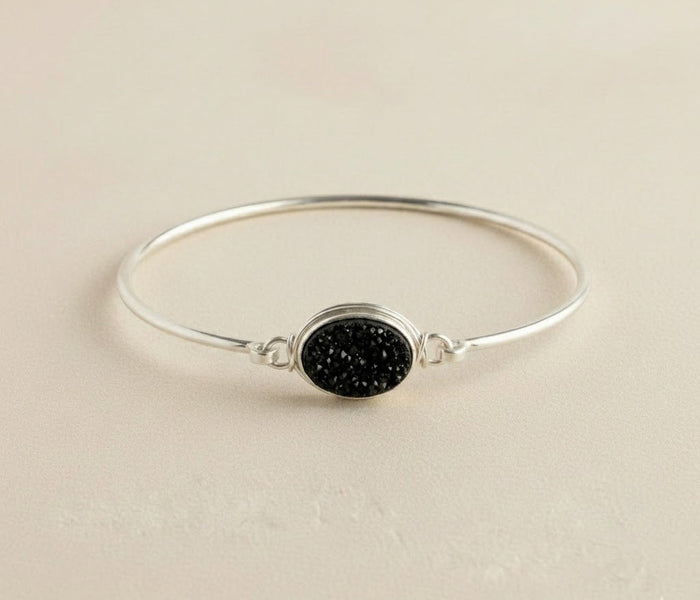 Sterling silver bangle bracelet with round black druzy stone centerpiece