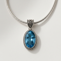 Silver snake-chain necklace with oval blue faceted filigree pendant