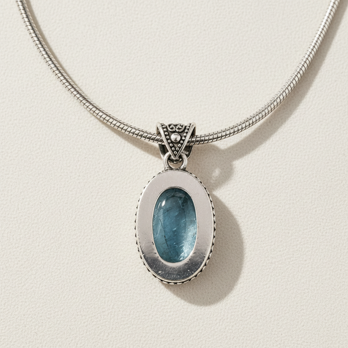 Silver snake-chain necklace with oval light-blue cabochon pendant in frame