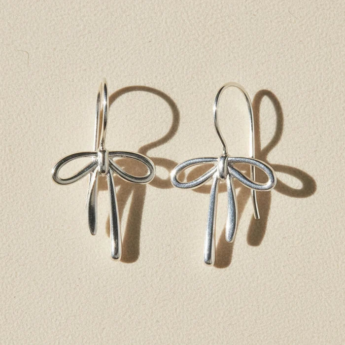 Silver bow tie ribbon drop earrings with dangling charms