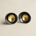 Gold-tone round stud earrings with dark circular bezel