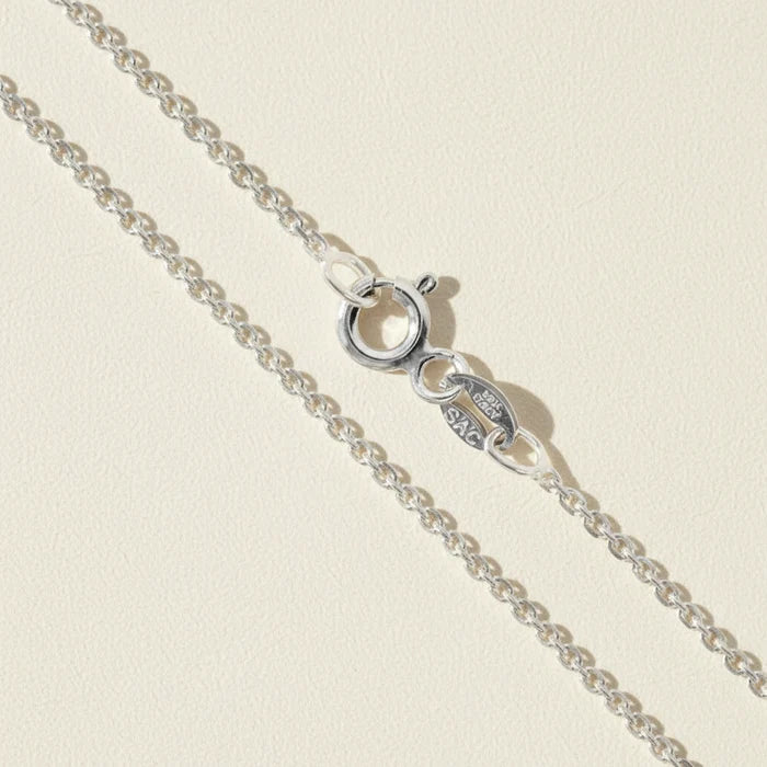 Silver cable chain necklace with circular clasp and oval logo charm