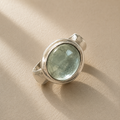Sterling silver ring with oval bezel-set light green cabochon gemstone
