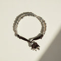 Necklace with silver beads and black ribbon on a white background