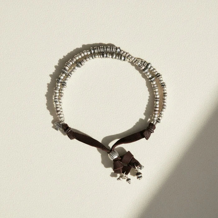 Necklace with silver beads and black ribbon on a white background