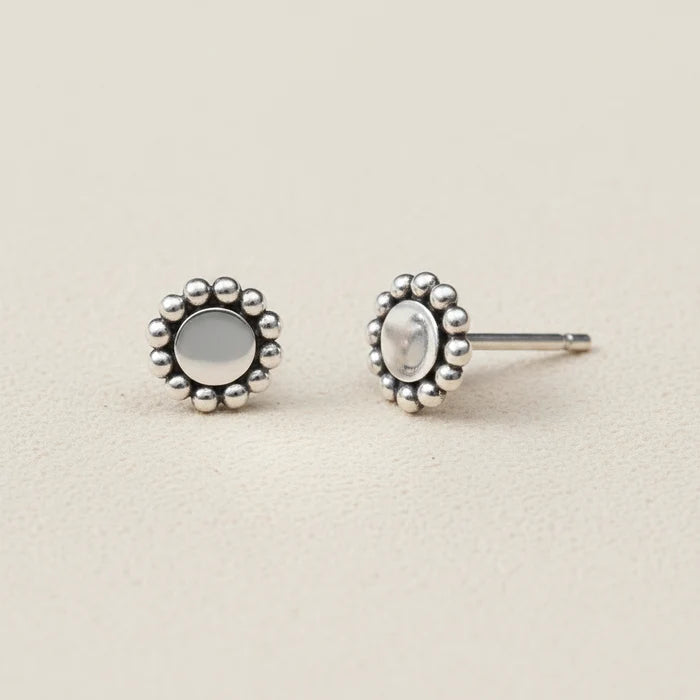Silver earrings with floral designs on a white background