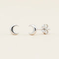 Silver crescent moon stud earrings with circular backing and push-back posts.