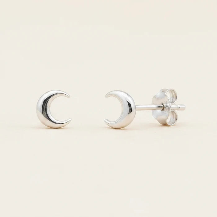 Silver crescent moon stud earrings with circular backing and push-back posts.