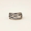 Silver ring with braided design on a white background