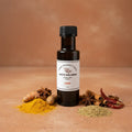 Curry White Balsamic Vinegar bottle with curry spices on terracotta surface