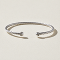 Twisted cuff bracelet with silver-tone wire and two round CZ-studded end caps.