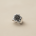 Silver ring with floral design on a white background