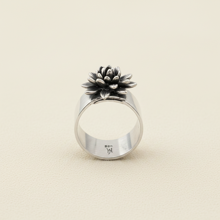 Adjustable silver ring with black-and-white flower centerpiece, round open band