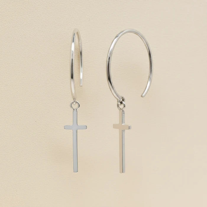 Silver hoop earrings with small cross charms dangling from hinged loops