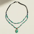 Necklace with turquoise beads and a pendant on a white background