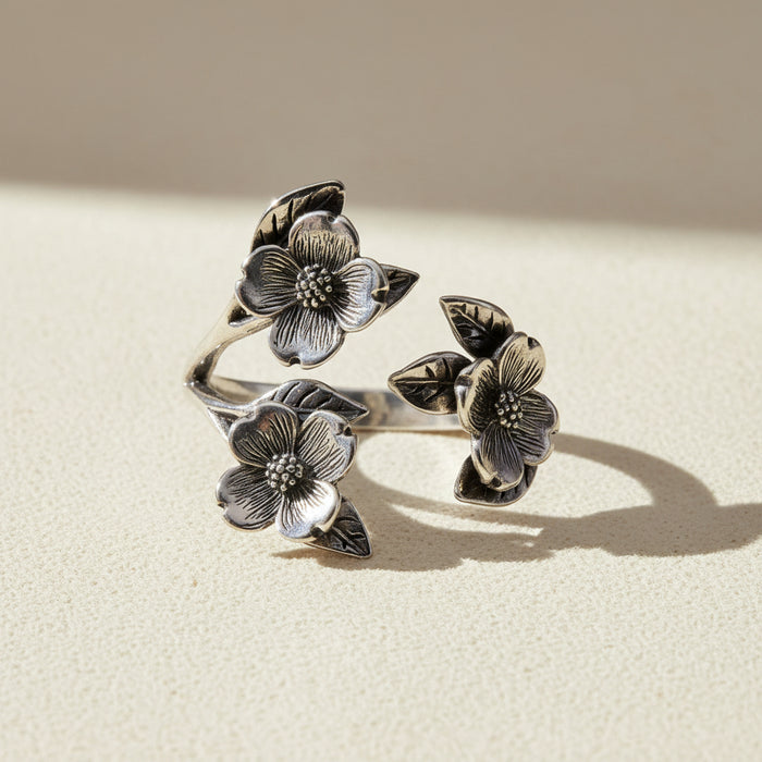 Silver flower ring with three dogwood blossoms and leaves, openwork band