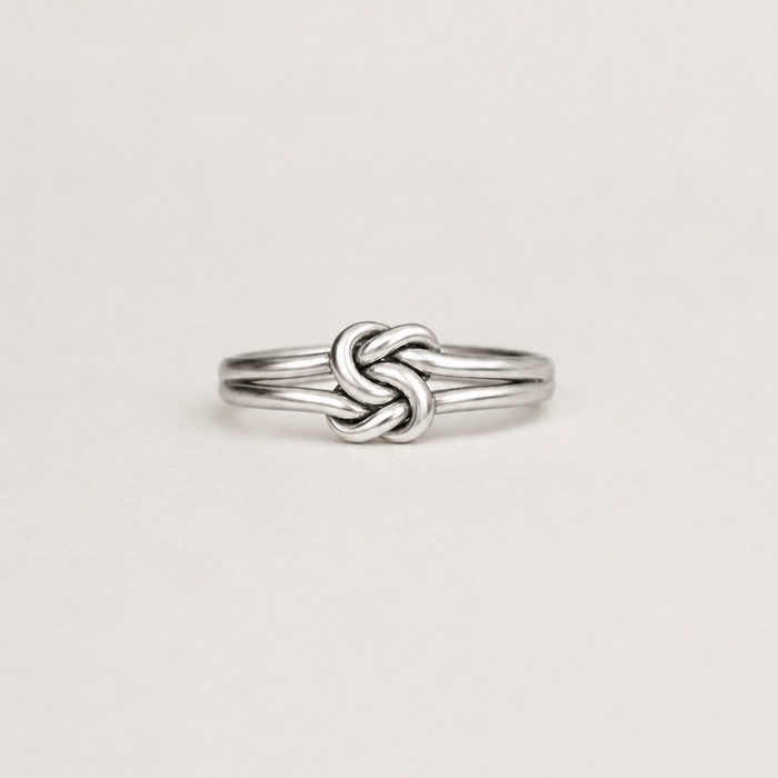 Silver double-knot style ring with polished braided band, slim profile