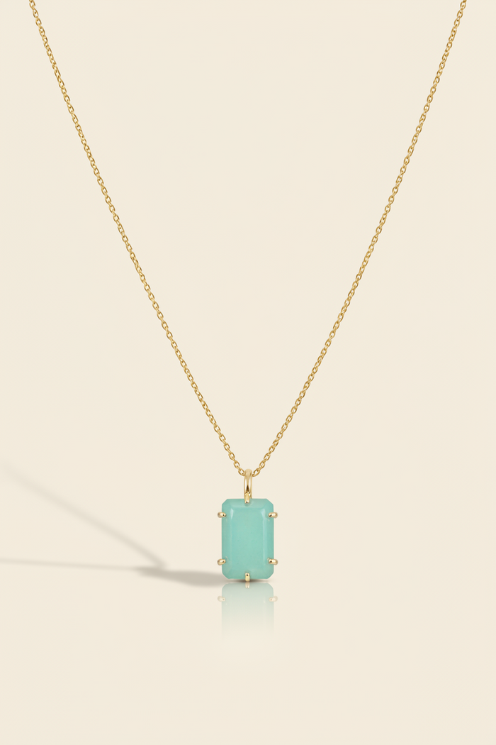 Aqua blue emerald-cut pendant necklace with gold-tone chain and bezel-set stone