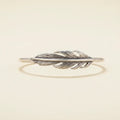 Silver feather-shaped bracelet on a white background