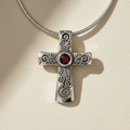 Silver filigree cross pendant necklace with red gemstone center