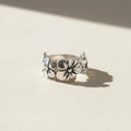 Silver ring with floral design on a white background