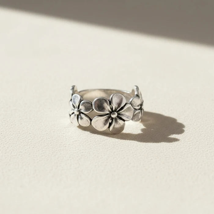Silver ring with floral design on a white background
