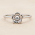 Flower ring with silver-tone band, four-petal flower and round crystal center
