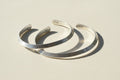 Silver cuff bracelet with engraved inner marking, open V-shaped profile