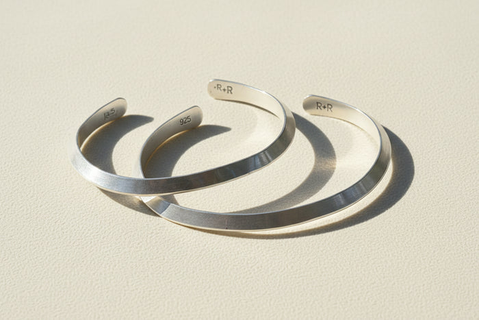 Silver cuff bracelet with engraved inner marking, open V-shaped profile