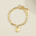 Gold-tone chain bracelet with heart charm and small round tag charm