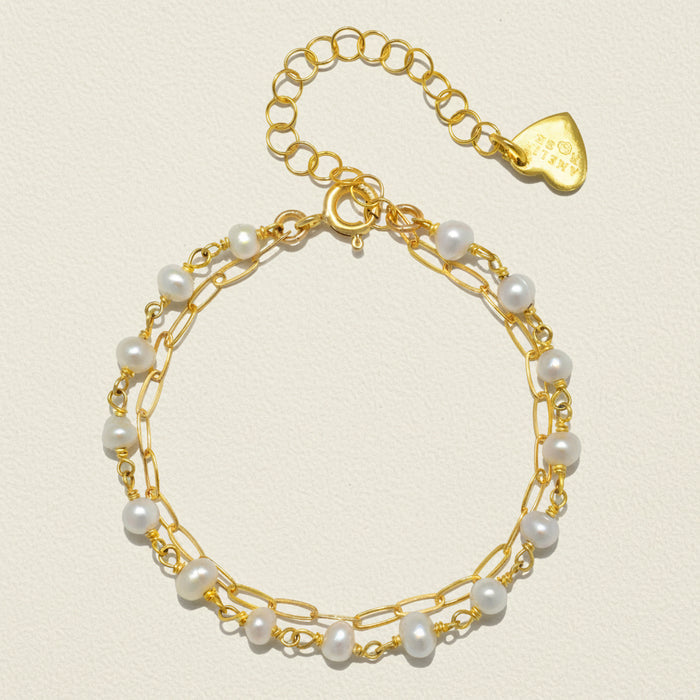 Gold-tone paperclip bracelet with white pearl beads and teardrop charm