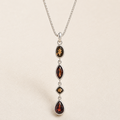 Gemstone drop necklace with four dark faceted marquise pendants and star accents