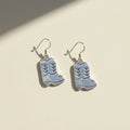 Silver cowboy boot earrings on a white background