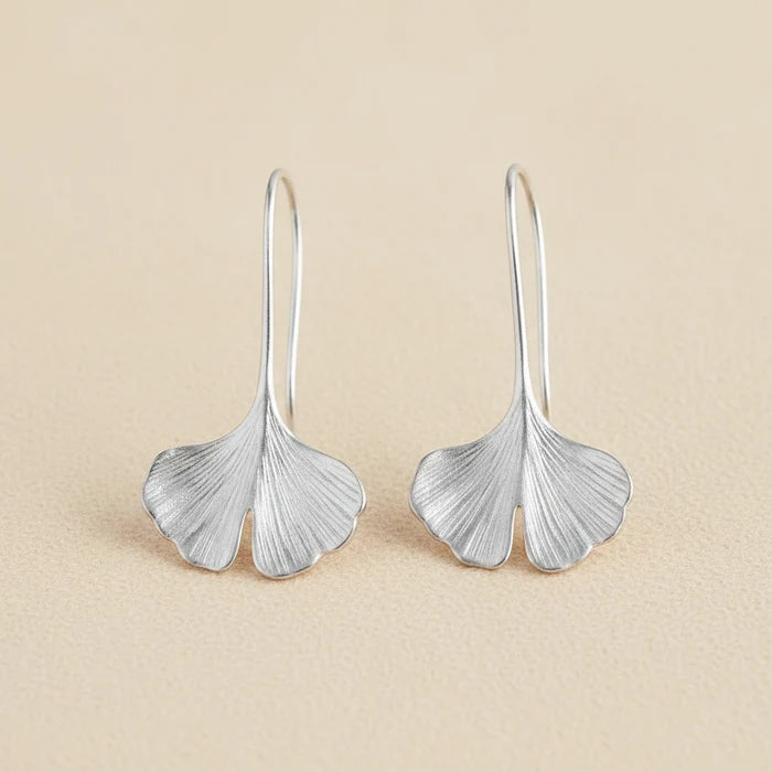 Silver ginkgo leaf drop earrings with curved leaf shapes and narrow hoop hooks.