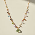 Gold-toned paperclip necklace with multicolor gemstone beads and green teardrop pendant