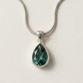 Green teardrop gemstone pendant on a silver-tone chain necklace