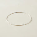 Silver-toned metal bangle bracelet with smooth oval shape