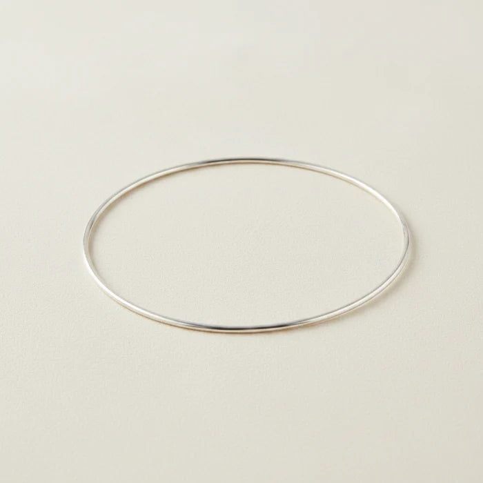 Silver-toned metal bangle bracelet with smooth oval shape