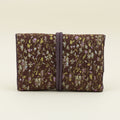 Floral fabric jewelry roll with dark tie strap, folded compartments