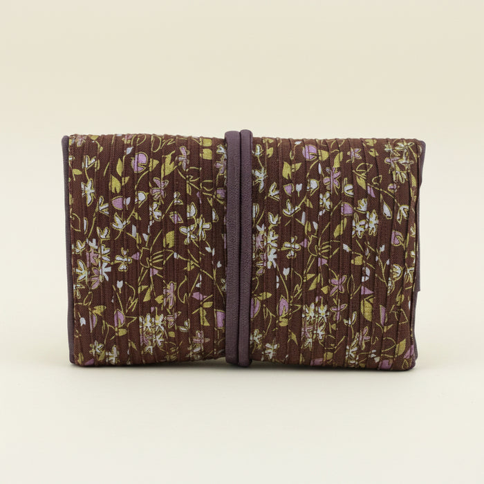 Floral fabric jewelry roll with dark tie strap, folded compartments