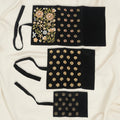 Black beaded jewelry roll with gold floral bead patterns and three storage panels