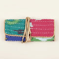 Colorful fabric clutch with a gold strap on a white background