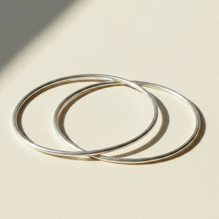 Pair of silver-tone infinite-loop bangle bracelets, overlapping open circles