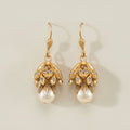 Gold-tone floral drop earrings with dangling faux pearl and textured charm caps