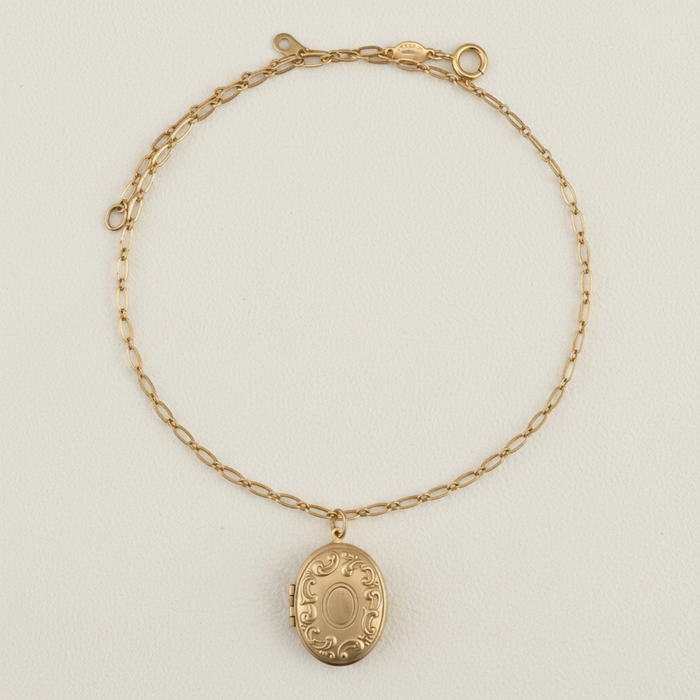 Gold-tone locket necklace with oval pendant and linked chain collar