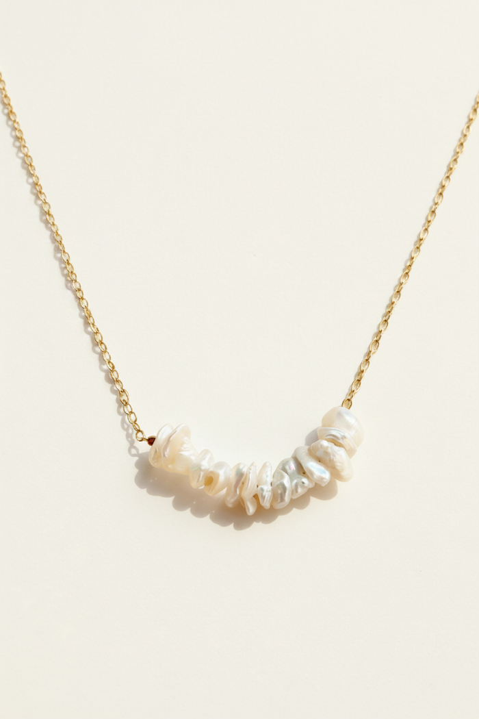 Keishi pearl row necklace, gold chain with white irregular pearls along curve