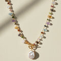 Gold toggle necklace with multicolor beads and a large white pearl drop pendant