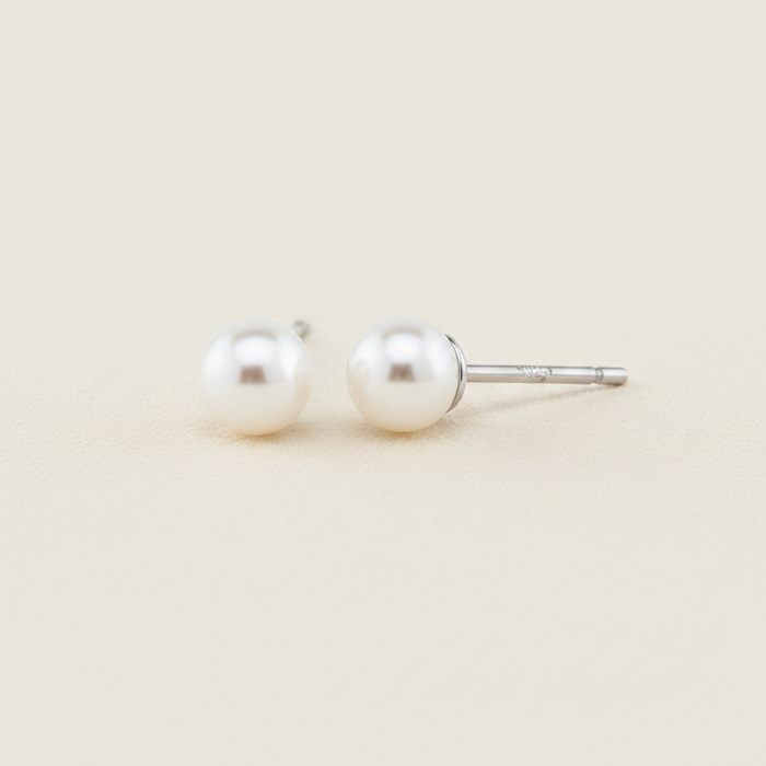 Large white pearl stud earrings with glossy round pearls on metal posts